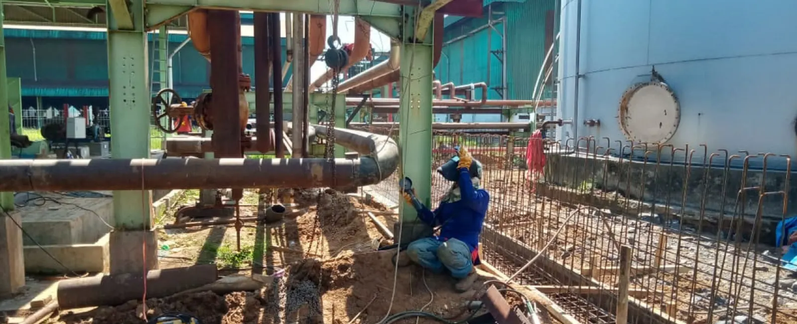 Pekerja mengelas pipa di area OSBL refinery plant