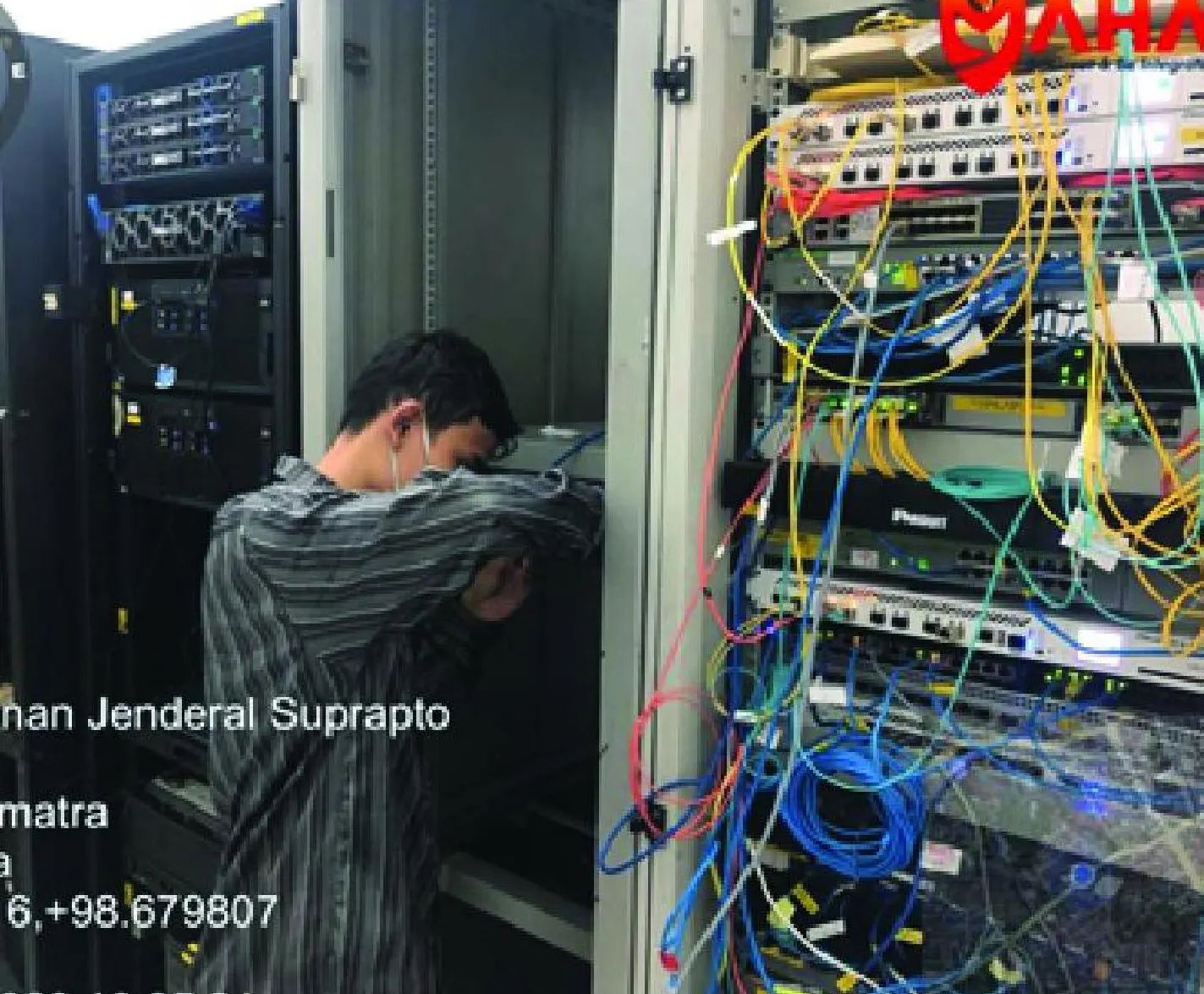 Teknisi merapikan kabel di rak server dan jaringan